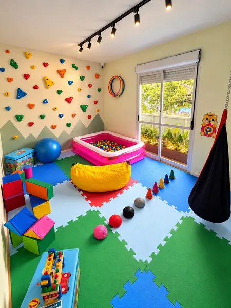 Sala de atividades, com parede de escalada, piscina de bolinhas e rede.